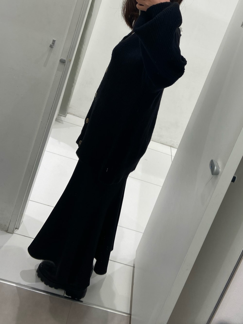 ブラック系のカーディガン/ボレロ、ブラック系のブーツを着用したレディースの春コーディネートの2枚目の写真