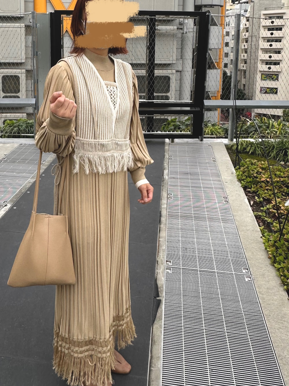 ベージュ系のワンピース、ブラウン系のローファー、ベージュ系のハンドバッグを着用したレディースの秋コーディネートの2枚目の写真
