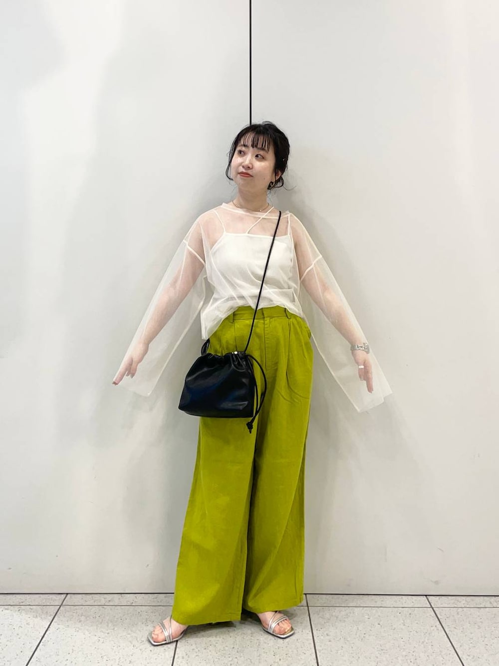 シルバー系のサンダル、ホワイト系のTシャツ/カットソー、グリーン系のスラックスを着用したレディースの春コーディネートの3枚目の写真