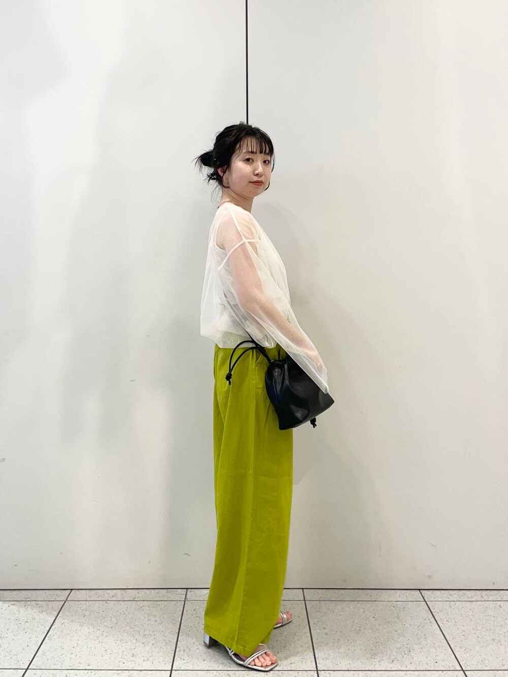 シルバー系のサンダル、ホワイト系のTシャツ/カットソー、グリーン系のスラックスを着用したレディースの春コーディネートの2枚目の写真