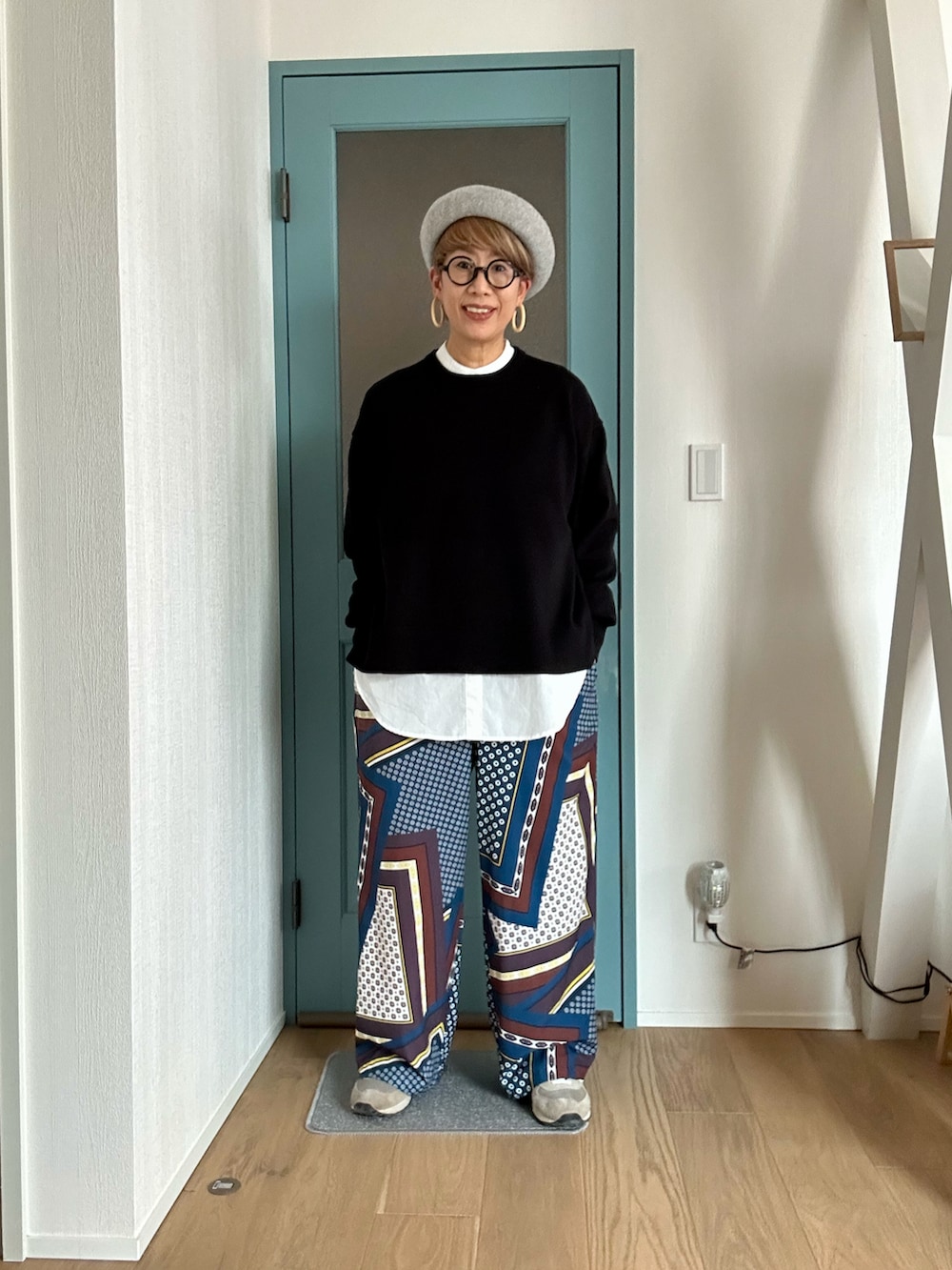 ブラック系のニット/セーター、ホワイト系のシャツ/ブラウス、その他のパンツを着用したレディースの冬コーディネートの2枚目の写真