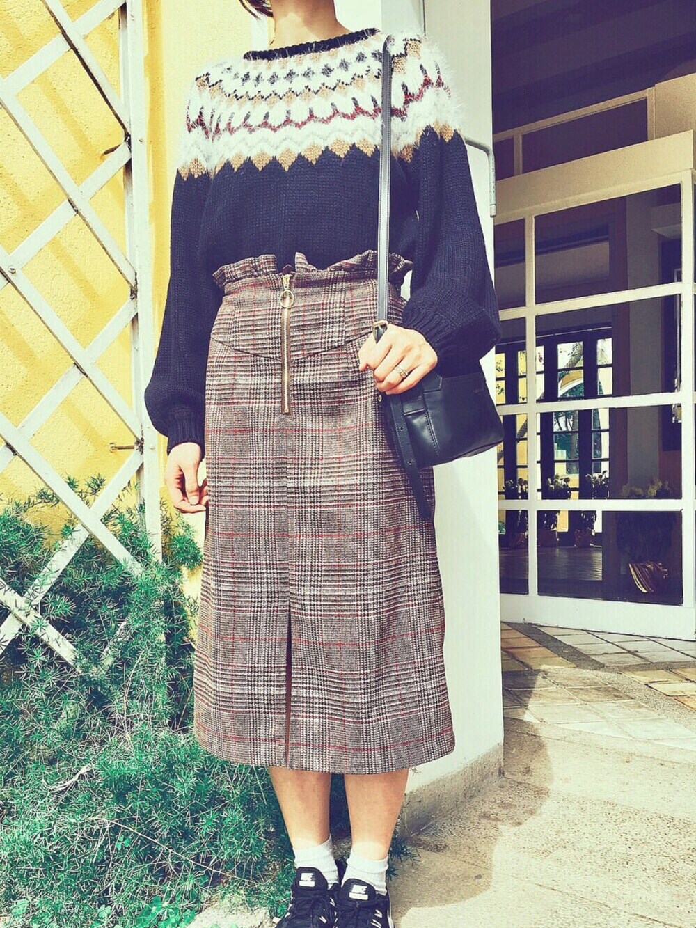 ブラック系のショルダーバッグ、ブラック系のスニーカーを着用したレディースの冬コーディネートの2枚目の写真