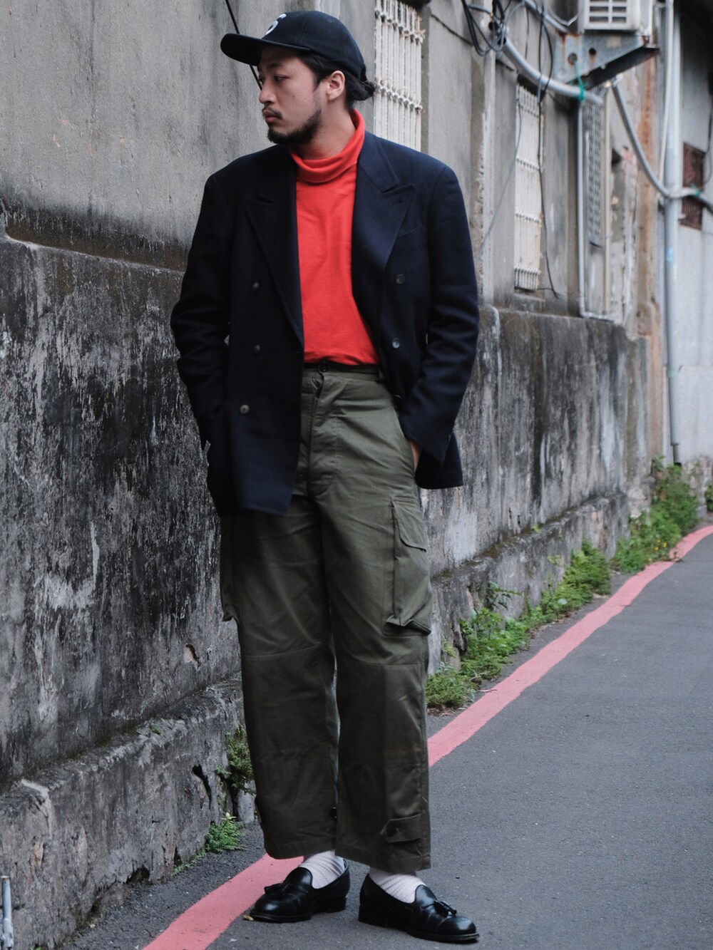 グリーン系のミリタリージャケット、ブラウン系のパンツ、ブラック系のローファーを着用したメンズの冬コーディネートの3枚目の写真