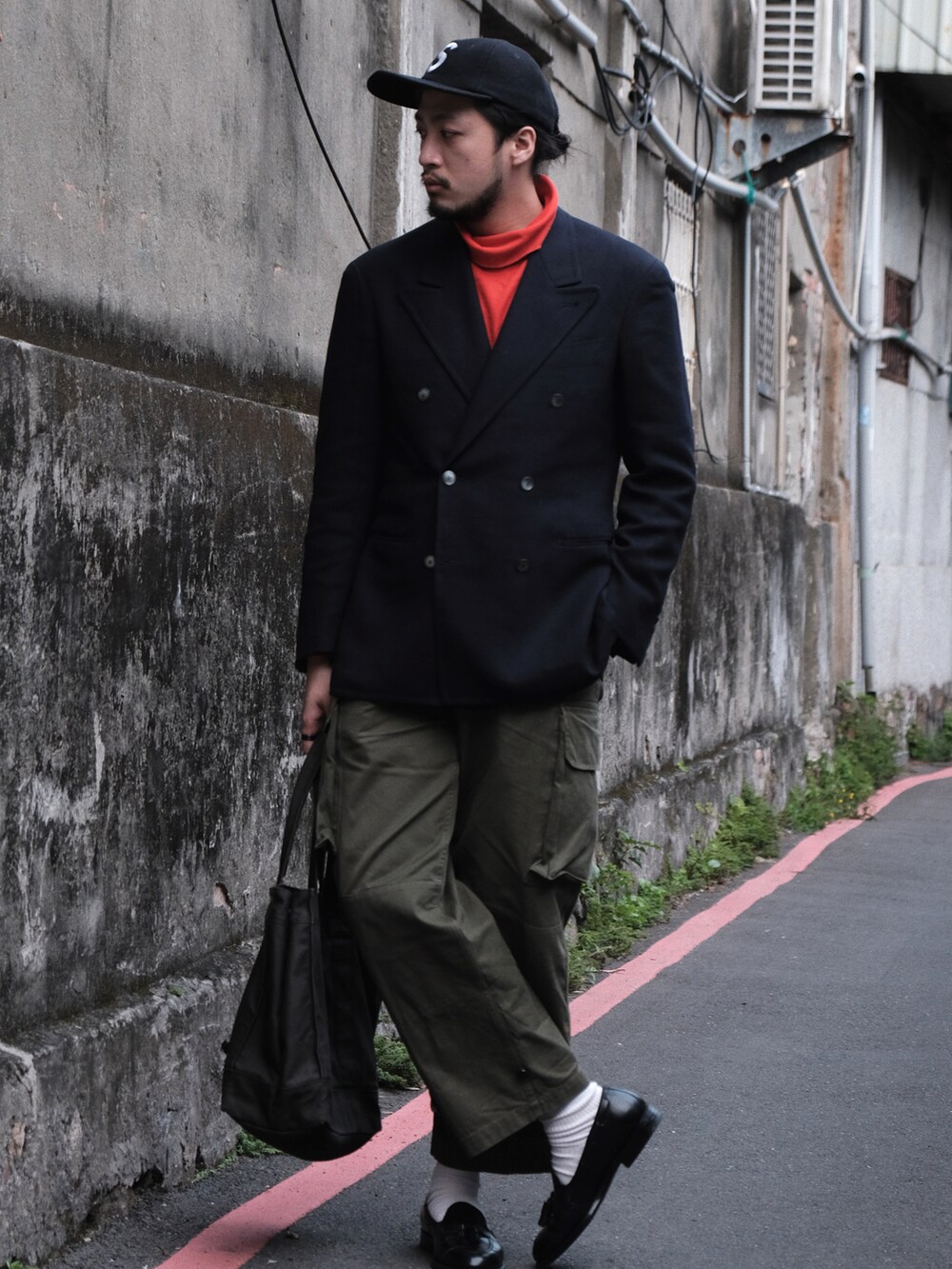 グリーン系のミリタリージャケット、ブラウン系のパンツ、ブラック系のローファーを着用したメンズの冬コーディネートの2枚目の写真