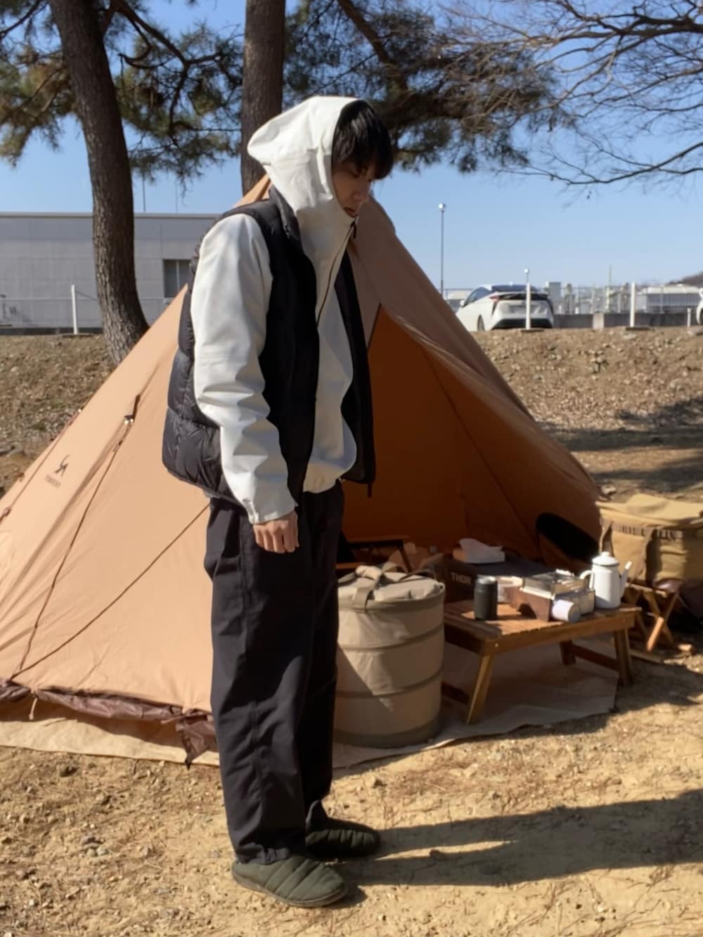 ブラック系のダウンベスト、ブラック系のその他パンツ、ホワイト系のナイロンジャケットを着用したメンズの冬コーディネートの2枚目の写真