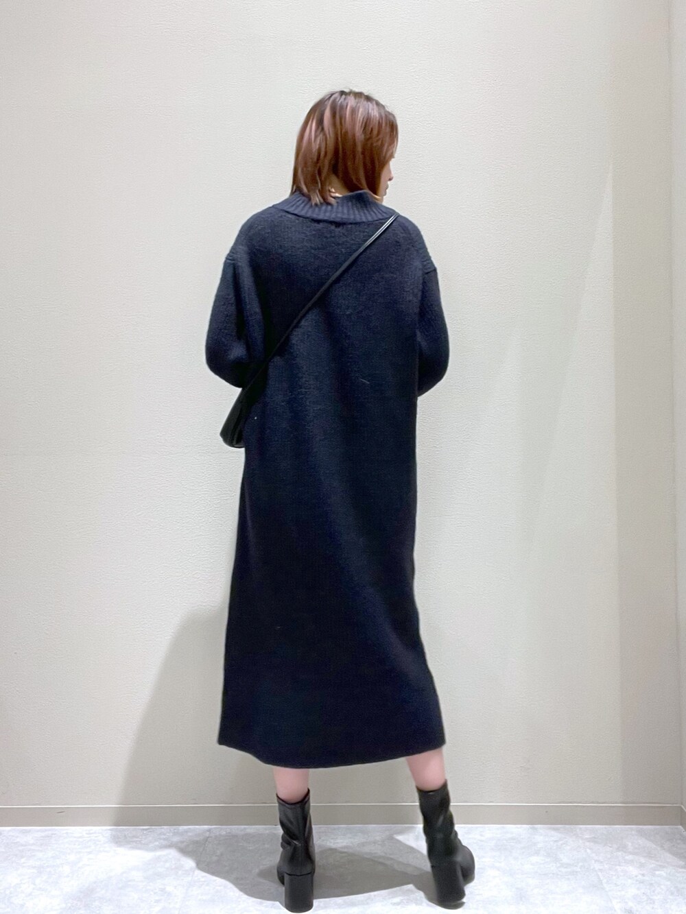 ブルー系のワンピース、ブラック系のショルダーバッグ、ブラック系のブーツを着用したレディースの秋コーディネートの3枚目の写真