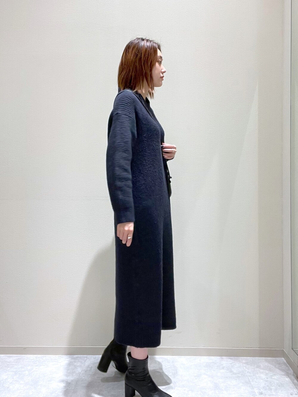 ブルー系のワンピース、ブラック系のショルダーバッグ、ブラック系のブーツを着用したレディースの秋コーディネートの2枚目の写真