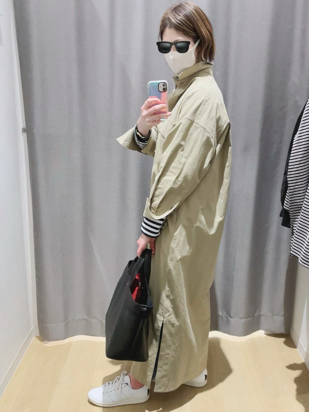 ブラック系のトートバッグ、ホワイト系のスニーカー、グリーン系のシャツワンピースを着用したレディースの冬コーディネートの2枚目の写真