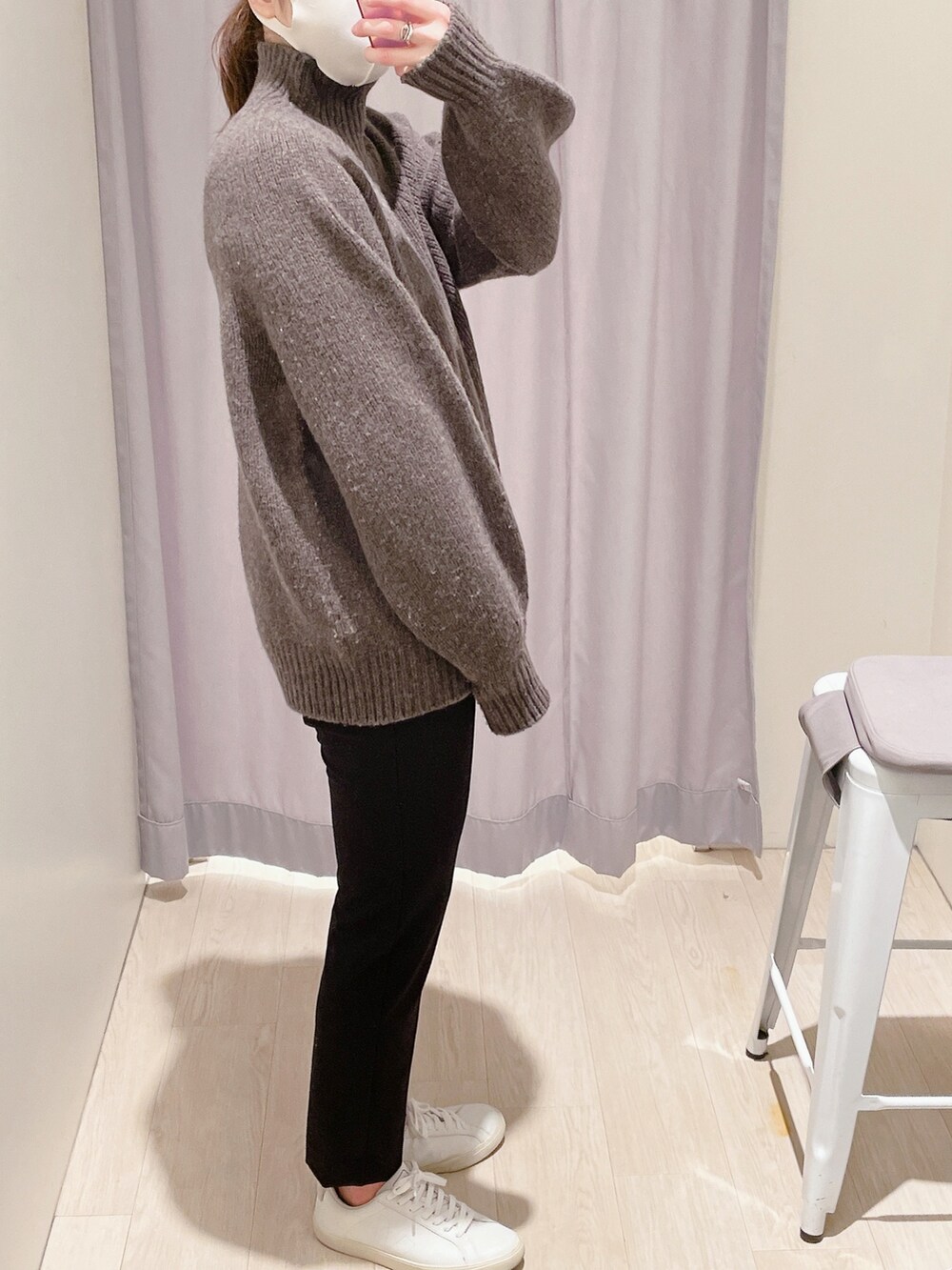 ブラック系のボストンバッグ、ブラック系のその他アウター、ブラウン系のニット/セーターを着用したレディースの冬コーディネートの2枚目の写真