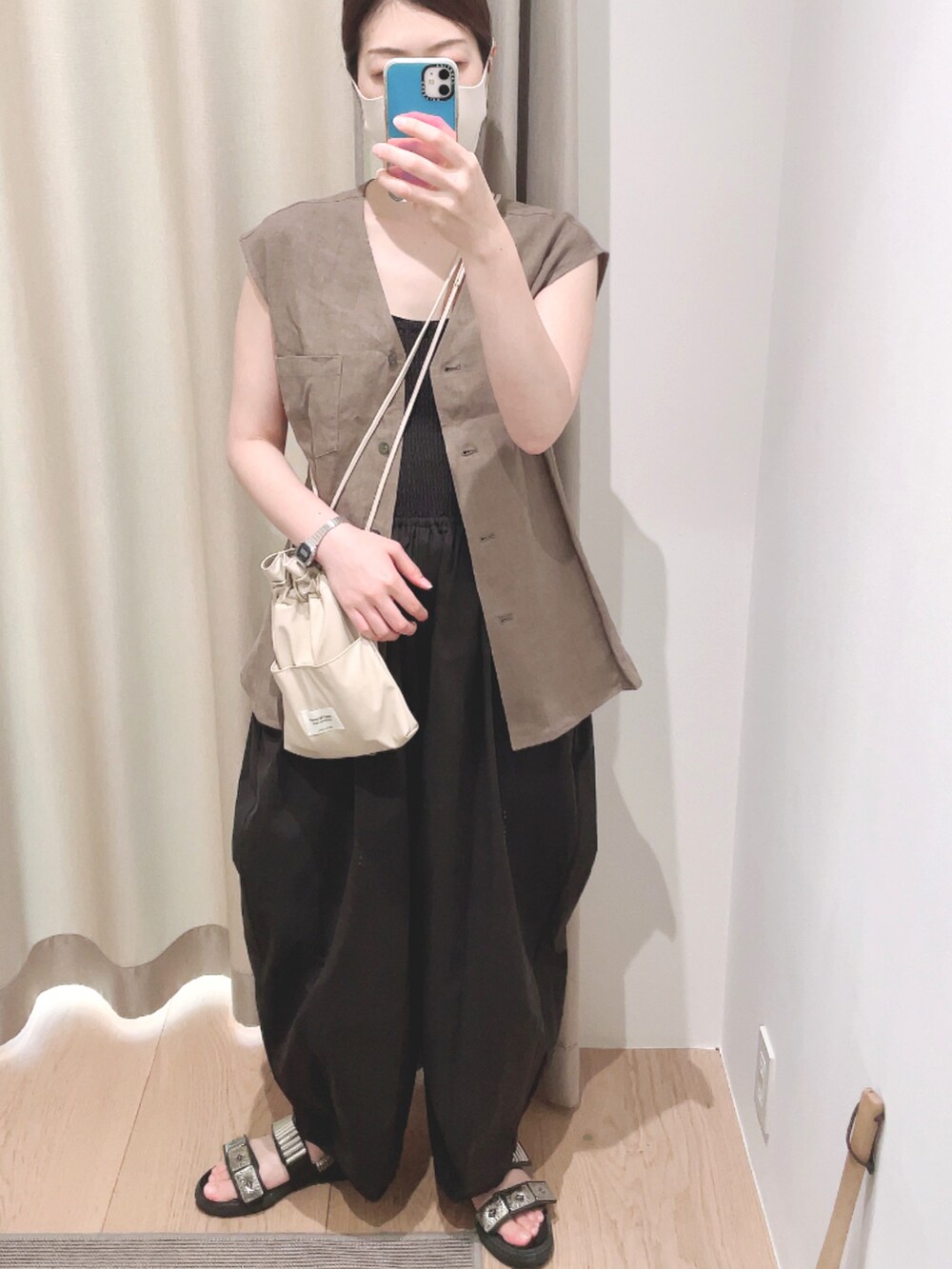 ベージュ系のベスト、ブラック系のサロペット/オーバーオール、ベージュ系のショルダーバッグを着用したレディースの夏コーディネートの2枚目の写真