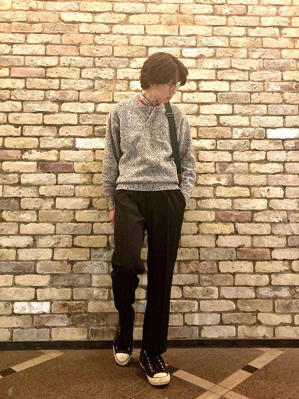 ブラウン系のスニーカー、ブラック系のスラックス、グレー系のニット/セーターを着用したメンズの秋コーディネートの2枚目の写真