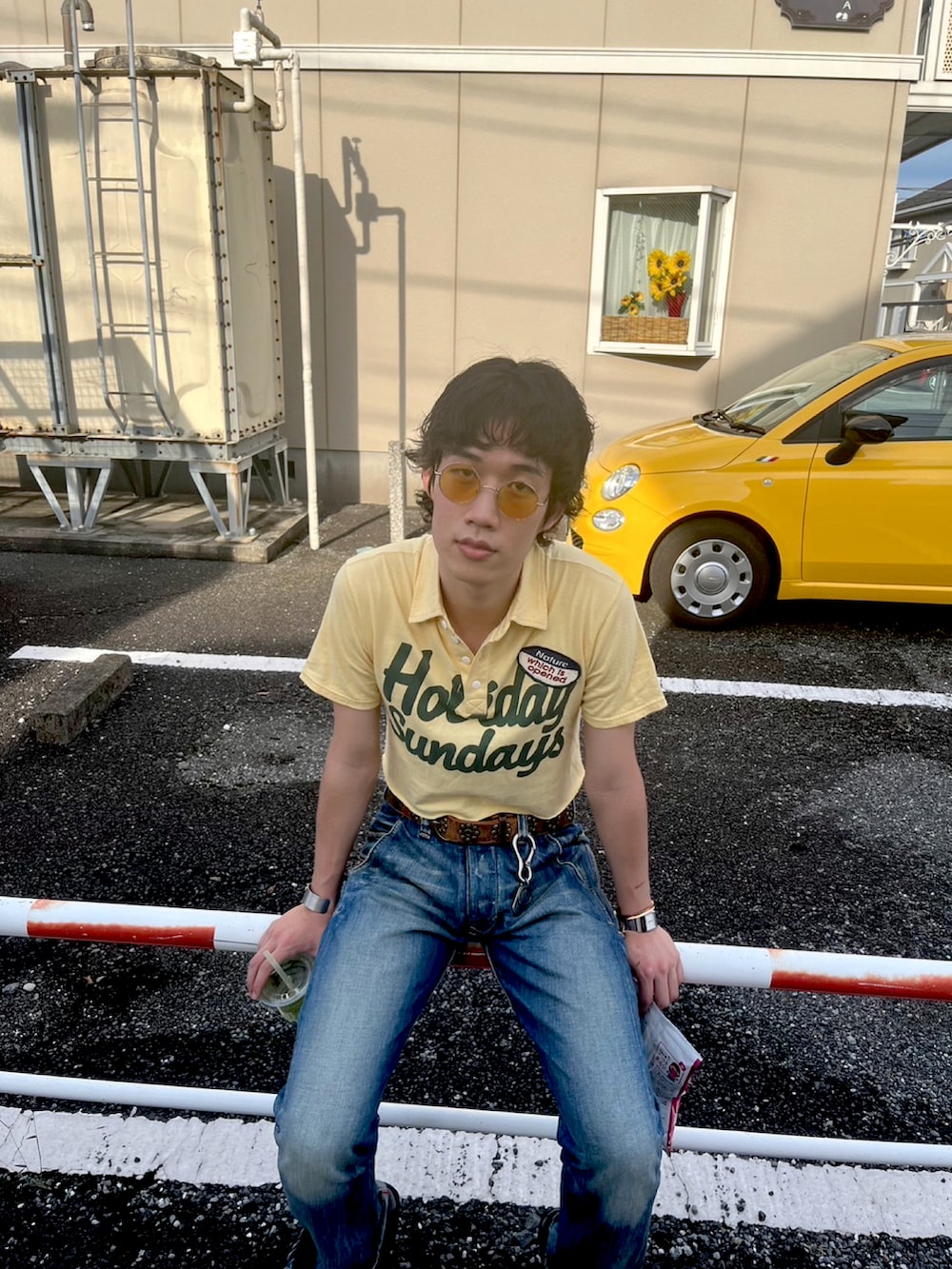 ブルー系のデニムパンツ、ブラック系のドレスシューズ、イエロー系のポロシャツを着用したメンズの夏コーディネートの2枚目の写真
