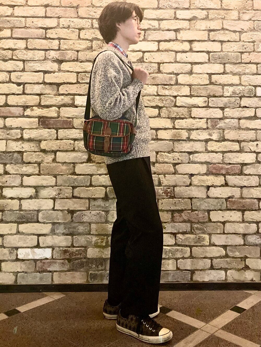 ブラウン系のスニーカー、ブラック系のスラックス、グレー系のニット/セーターを着用したメンズの秋コーディネートの3枚目の写真