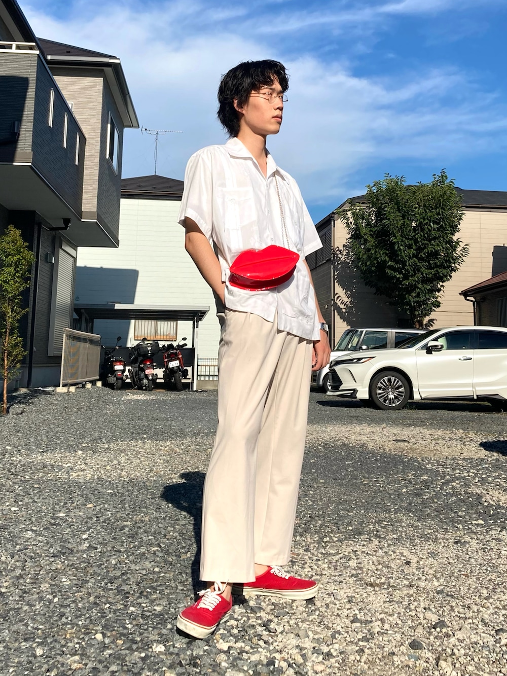 レッド系のスニーカー、ホワイト系のスラックス、ホワイト系のシャツ/ブラウスを着用したメンズの夏コーディネートの2枚目の写真