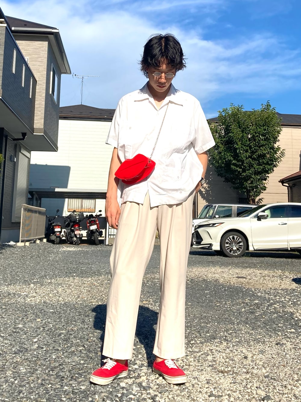 レッド系のスニーカー、ホワイト系のスラックス、ホワイト系のシャツ/ブラウスを着用したメンズの夏コーディネートの3枚目の写真