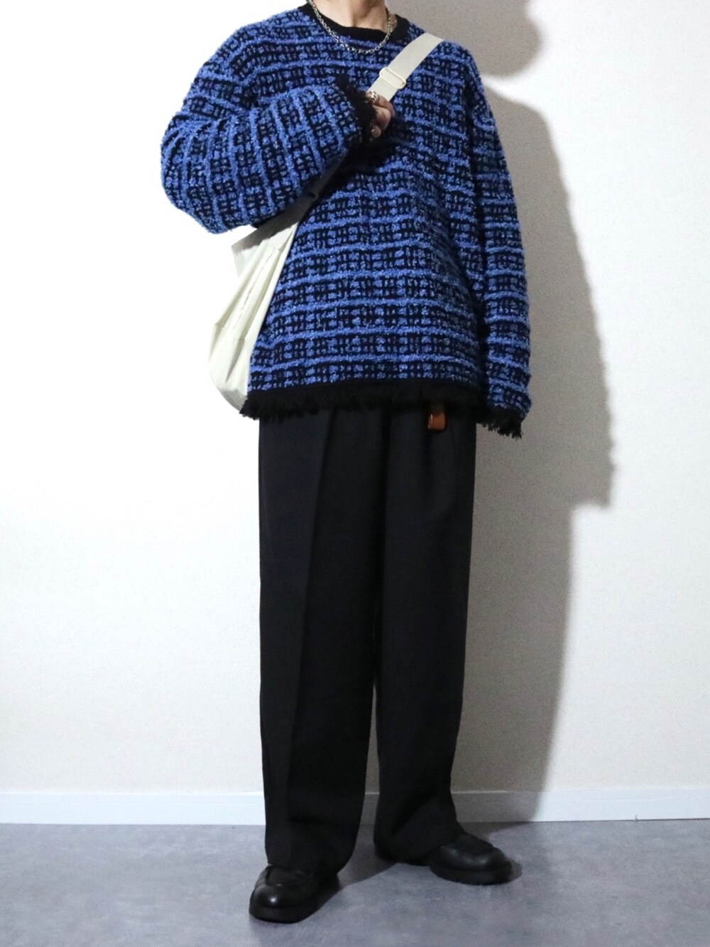 ブラック系のブルゾン、ブルー系のニット/セーター、ブラック系のドレスシューズを着用したメンズの冬コーディネートの2枚目の写真