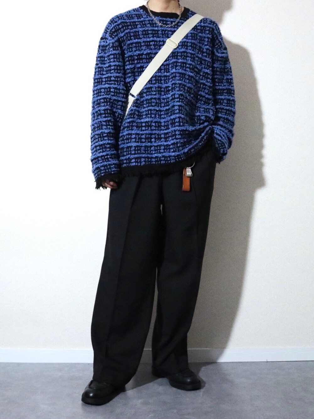 ブラック系のブルゾン、ブルー系のニット/セーター、ブラック系のドレスシューズを着用したメンズの冬コーディネートの3枚目の写真