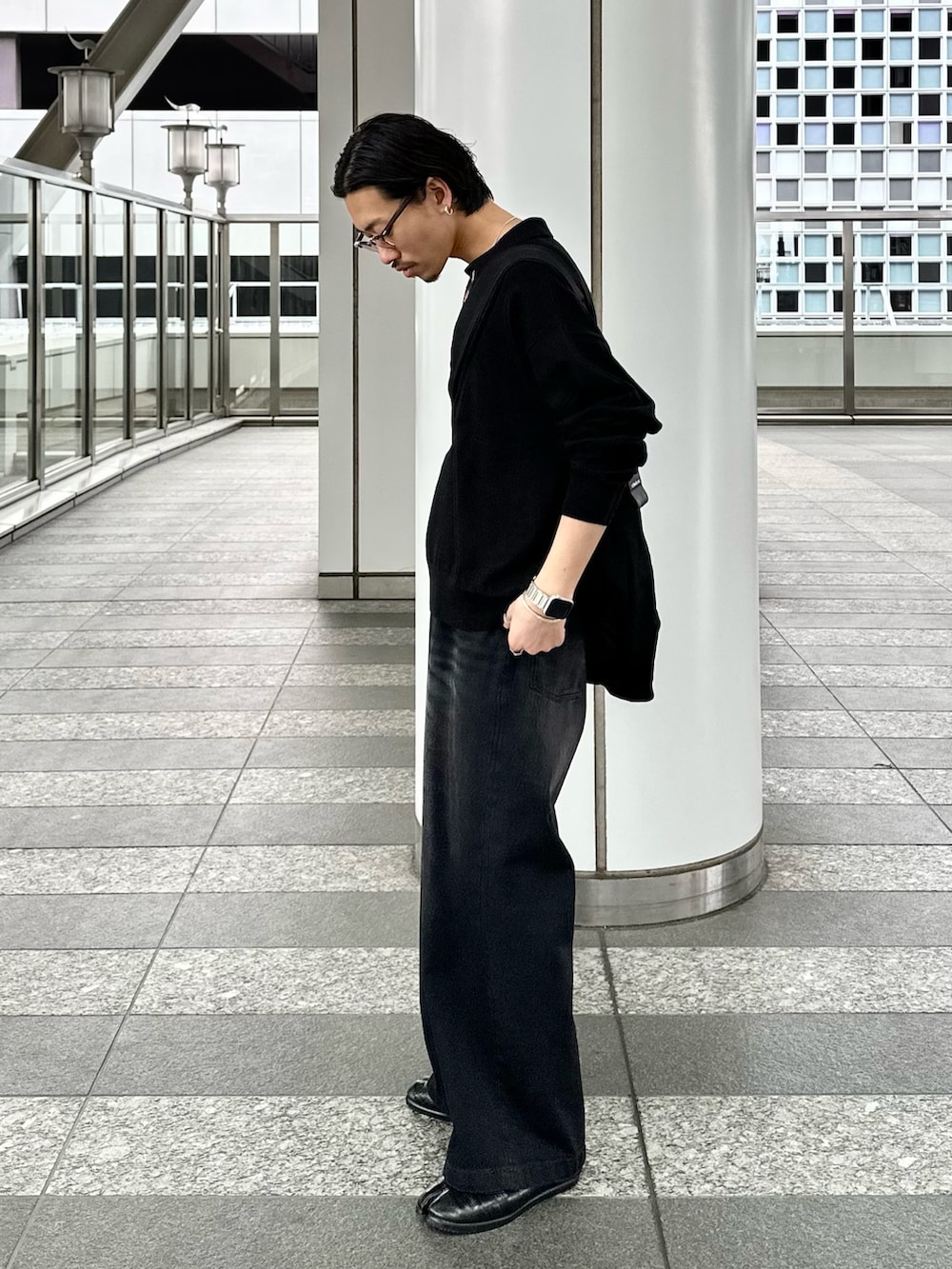 ブラック系のニット/セーター、ブラック系のデニムパンツを着用したメンズの春コーディネートの2枚目の写真