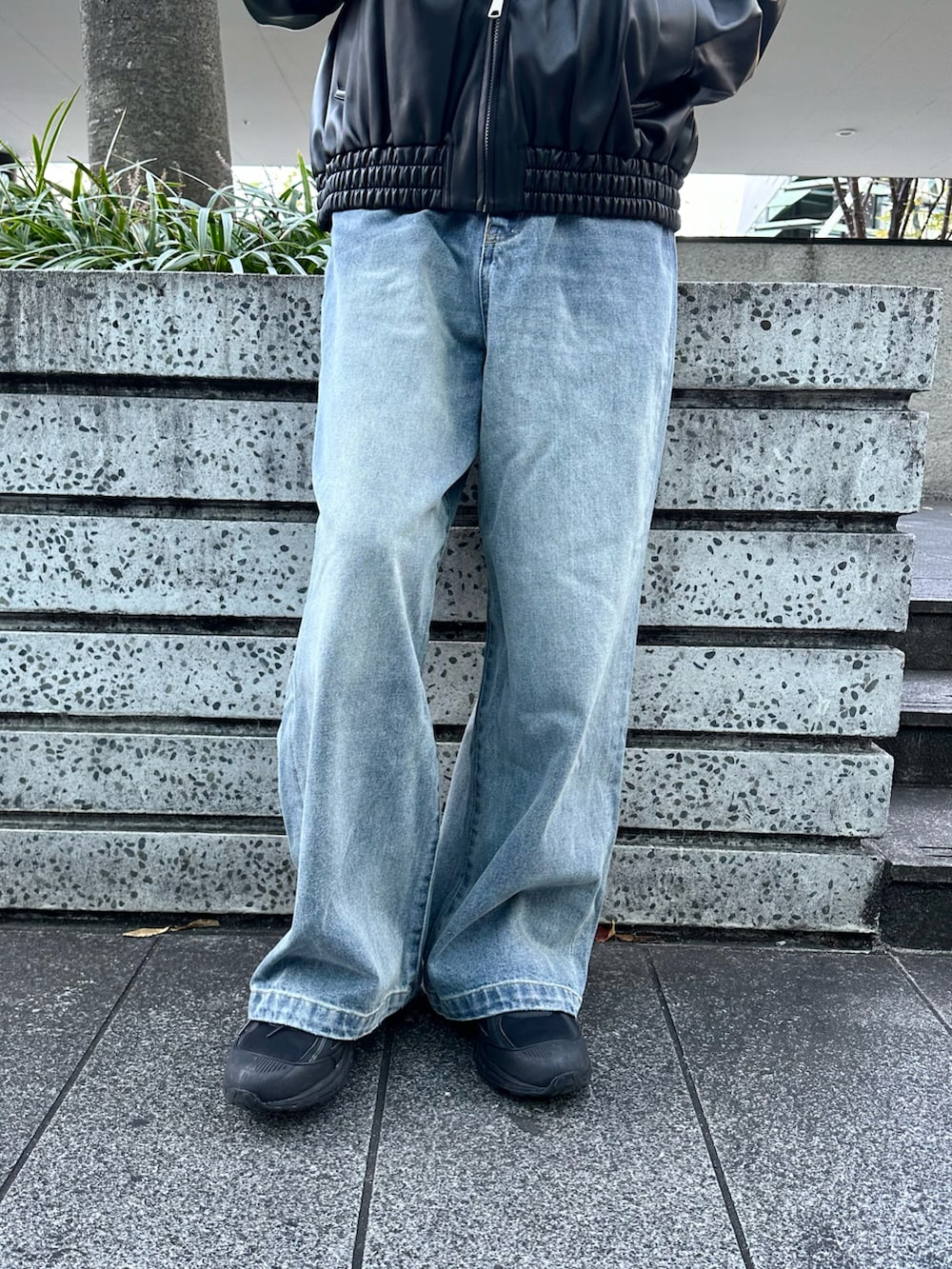 ブラック系のブルゾン、グレー系のニット/セーター、ブルー系のデニムパンツを着用したメンズの冬コーディネートの5枚目の写真