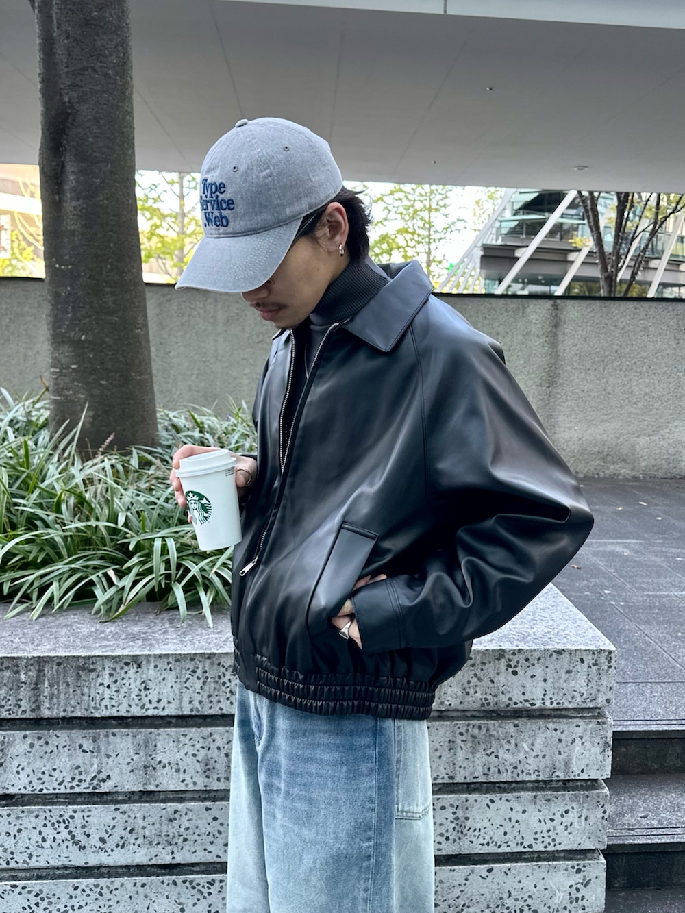 ブラック系のブルゾン、グレー系のニット/セーター、ブルー系のデニムパンツを着用したメンズの冬コーディネートの4枚目の写真