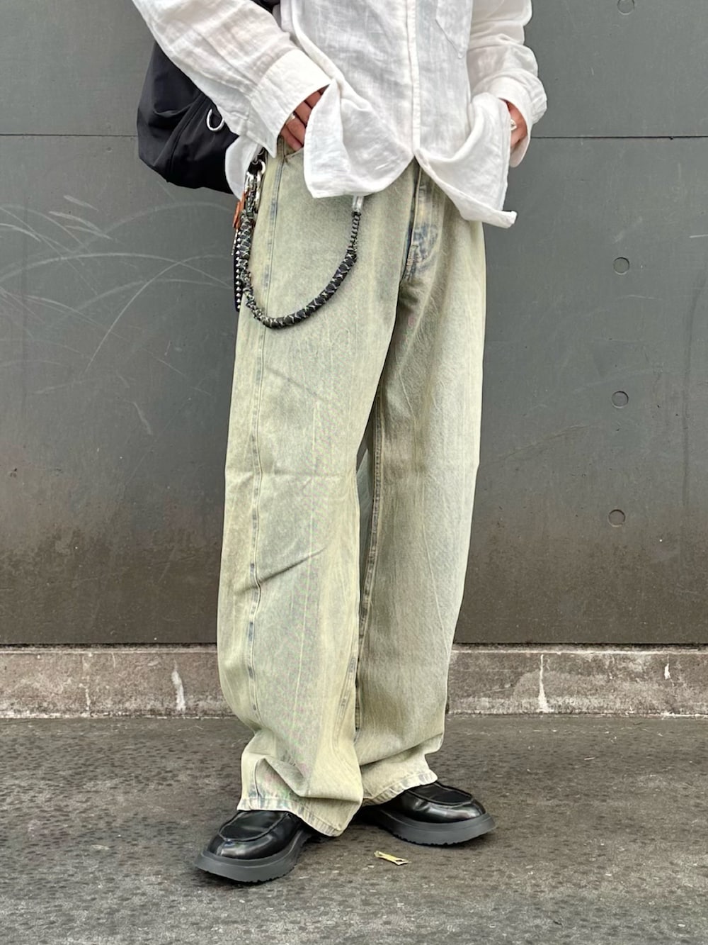 グリーン系のデニムパンツ、ブラック系のショルダーバッグを着用したメンズの夏コーディネートの5枚目の写真