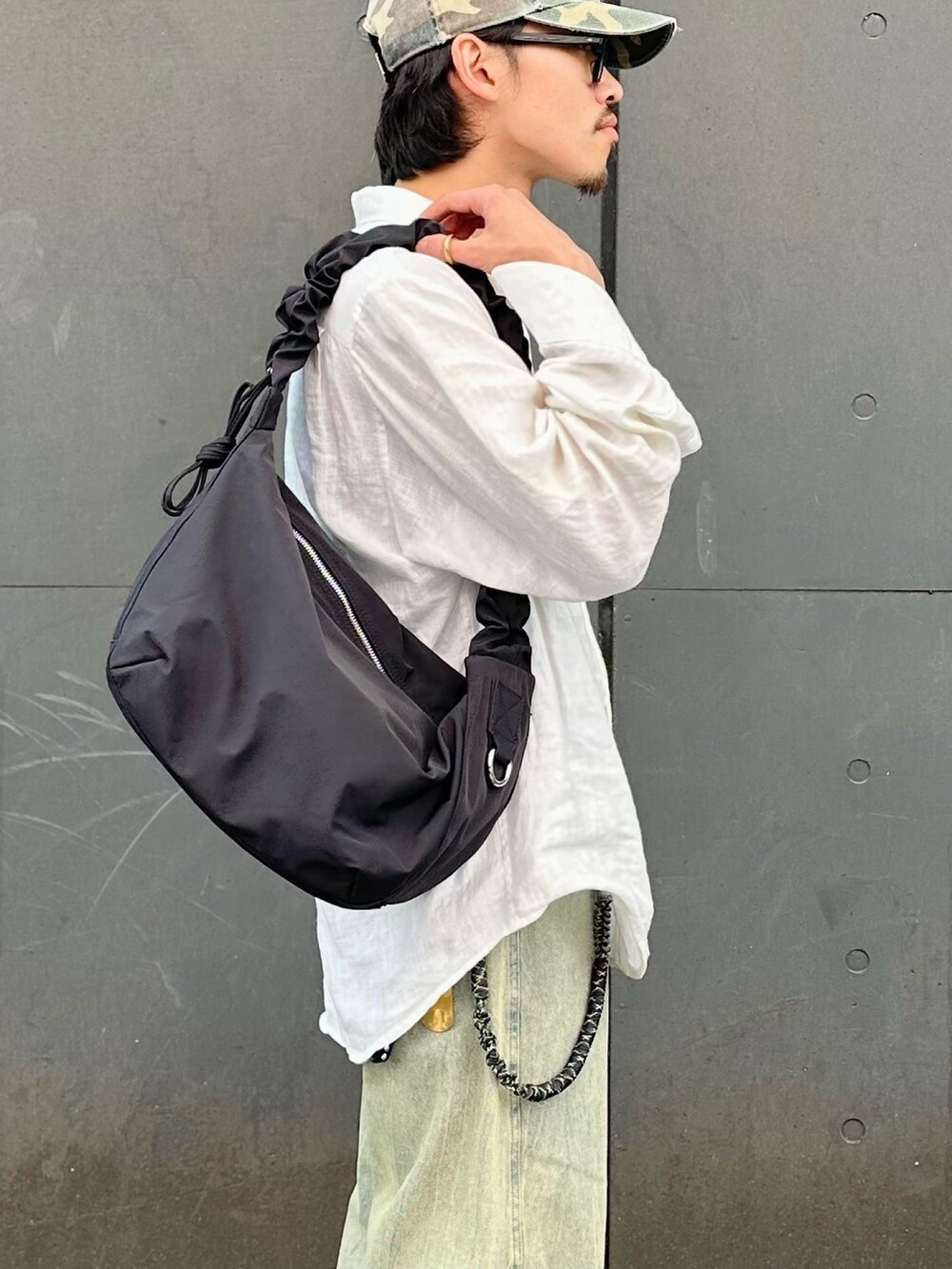 グリーン系のデニムパンツ、ブラック系のショルダーバッグを着用したメンズの夏コーディネートの4枚目の写真