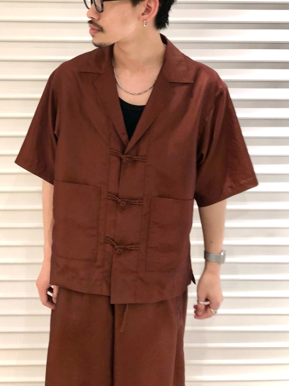 ブラウン系のシャツ/ブラウス、ブラウン系のその他パンツ、ブラック系のモカシン/デッキシューズを着用したメンズの春コーディネートの2枚目の写真