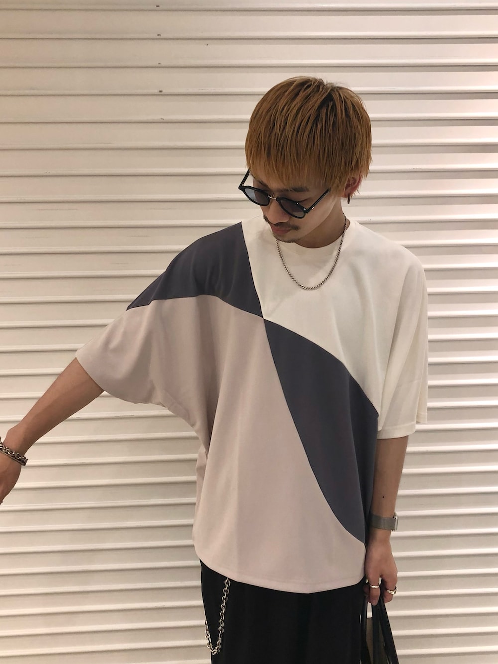 ホワイト系のTシャツ/カットソー、ブラック系のスラックス、ブラック系のトートバッグを着用したメンズの夏コーディネートの2枚目の写真