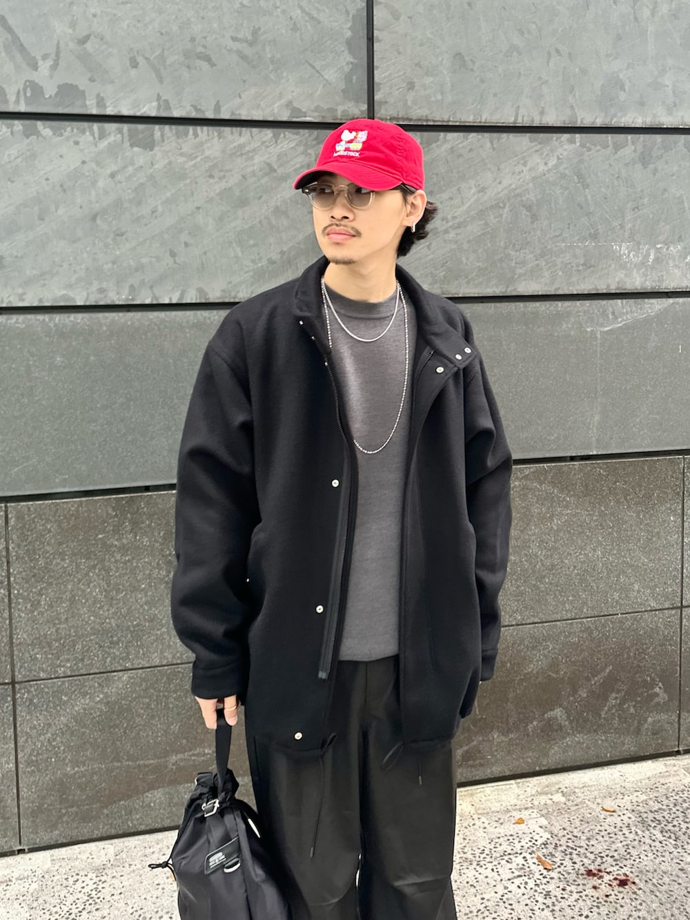 ブラック系のその他アウター、グレー系のニット/セーター、ブラック系のその他パンツを着用したメンズの冬コーディネートの4枚目の写真