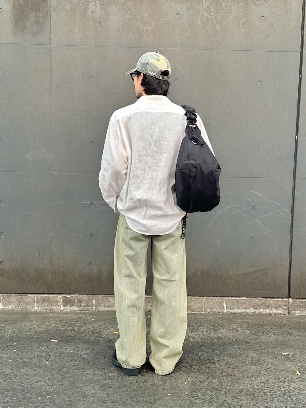 グリーン系のデニムパンツ、ブラック系のショルダーバッグを着用したメンズの夏コーディネートの3枚目の写真