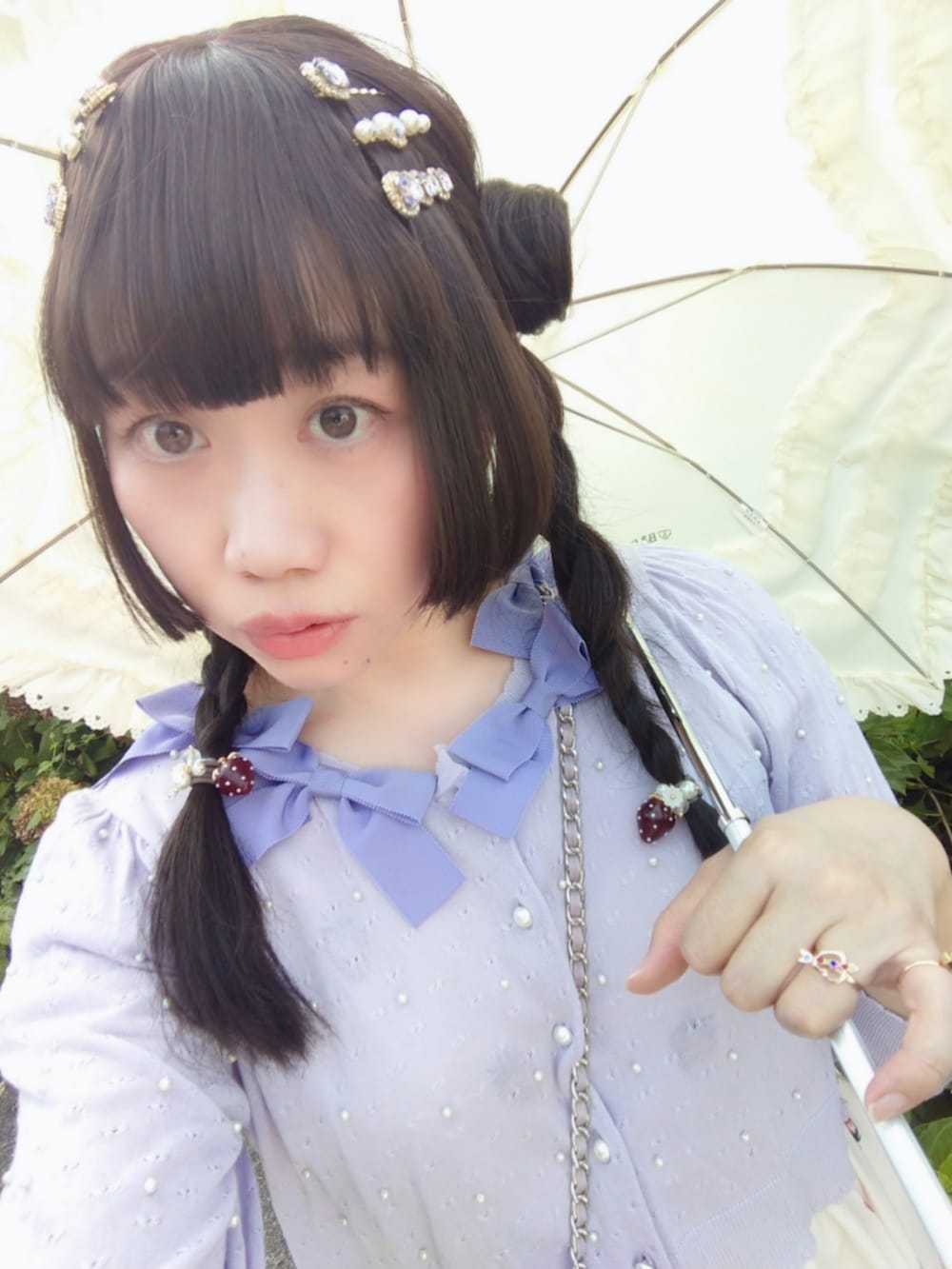 ピンク系のショルダーバッグ、パープル系のカーディガン/ボレロ、ホワイト系のワンピースを着用したレディースの秋コーディネートの3枚目の写真