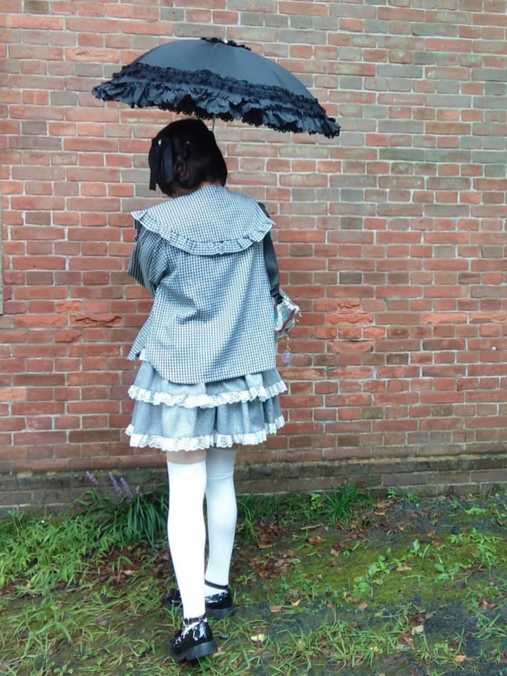 ブラック系のシャツ/ブラウス、ブラック系のスカート、ブラック系のパンプスを着用したレディースの秋コーディネートの2枚目の写真