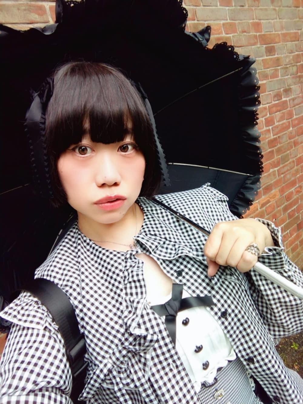 ブラック系のシャツ/ブラウス、ブラック系のスカート、ブラック系のパンプスを着用したレディースの秋コーディネートの3枚目の写真