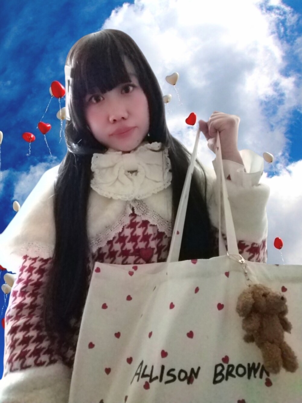 ホワイト系のトートバッグ、レッド系のその他アウター、ホワイト系のポンチョを着用したレディースの冬コーディネートの2枚目の写真