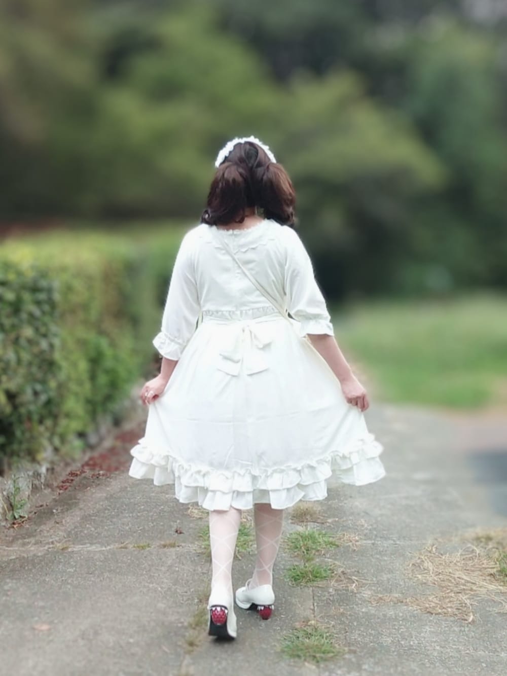 ホワイト系のワンピース、ホワイト系のショルダーバッグ、ホワイト系のパンプスを着用したレディースの秋コーディネートの2枚目の写真