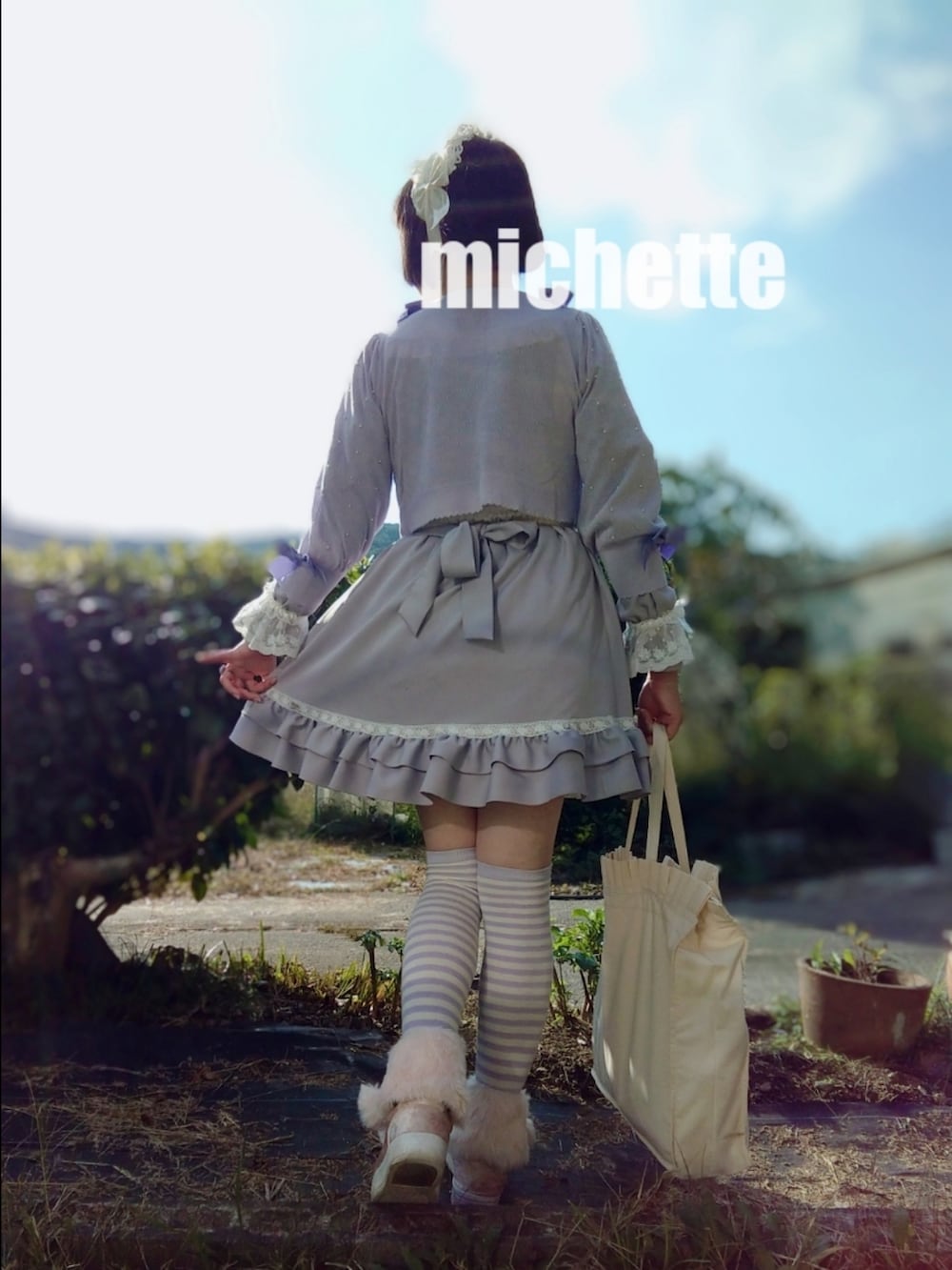 ホワイト系のトートバッグ、パープル系のカーディガン/ボレロ、パープル系のワンピースを着用したレディースの秋コーディネートの3枚目の写真