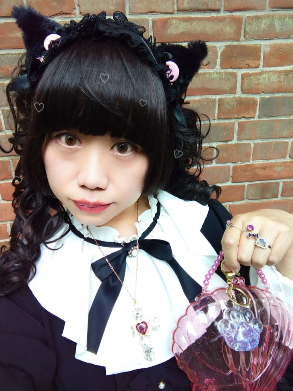 ブラック系のワンピース、ブラック系のパンプス、ピンク系のハンドバッグを着用したレディースの春コーディネートの4枚目の写真