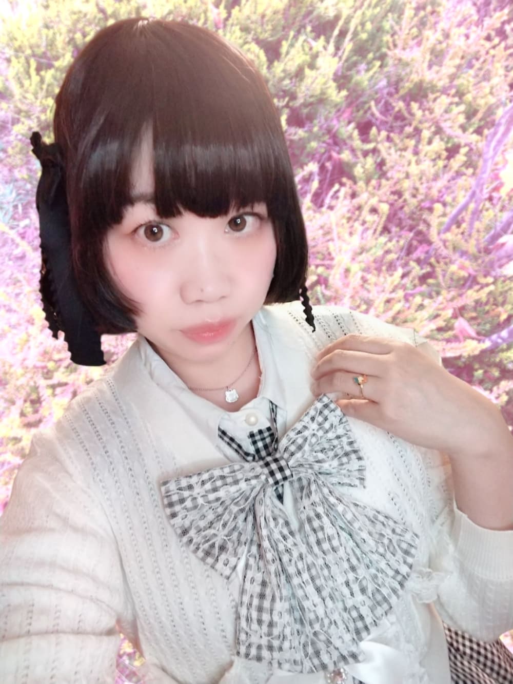 ホワイト系のカーディガン/ボレロ、ブラック系のセットアップ、ブラック系のパンプスを着用したレディースの秋コーディネートの2枚目の写真