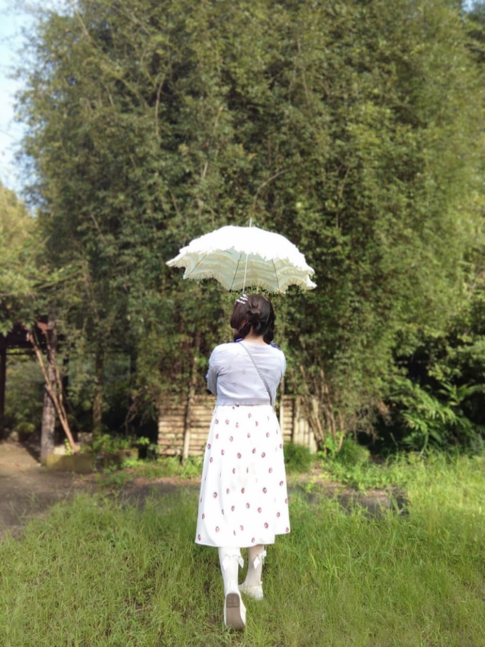 ピンク系のショルダーバッグ、パープル系のカーディガン/ボレロ、ホワイト系のワンピースを着用したレディースの秋コーディネートの2枚目の写真