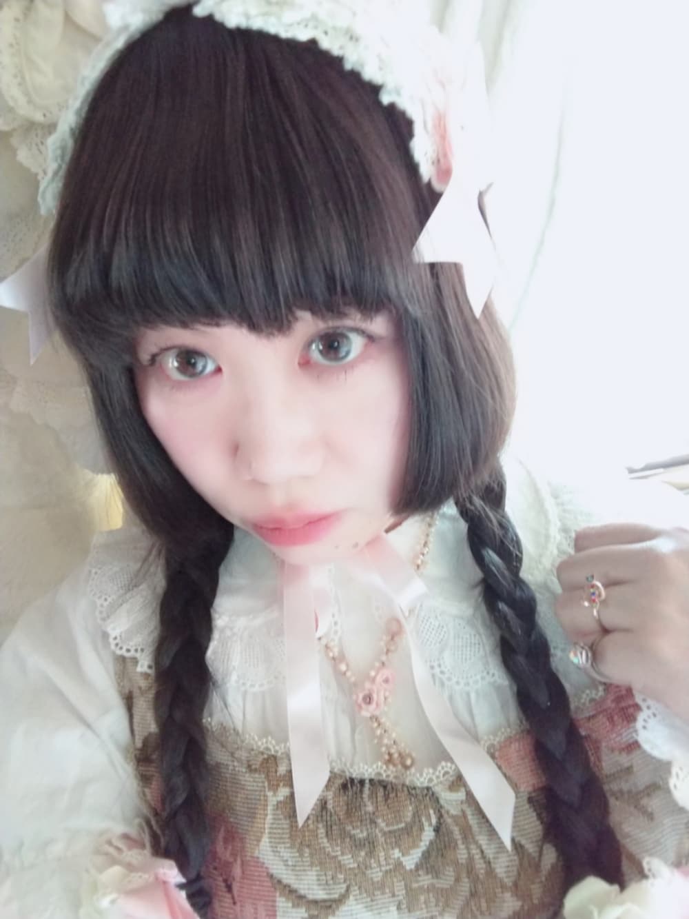 ピンク系のパンプス、ベージュ系のジャンパースカート、ホワイト系のシャツ/ブラウスを着用したレディースの春コーディネートの2枚目の写真