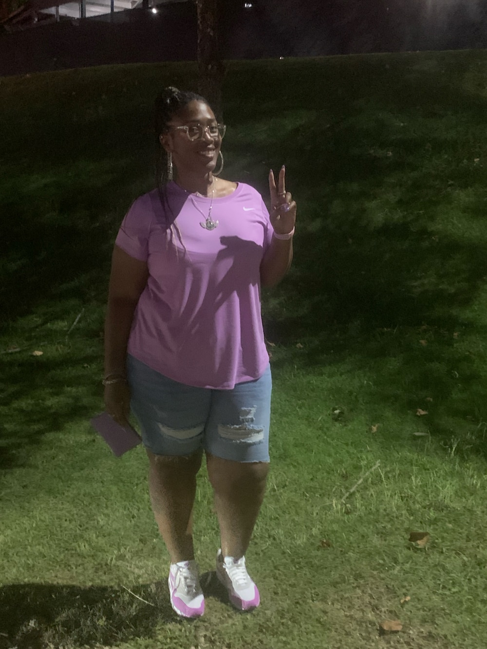 パープル系のTシャツ/カットソー、パープル系のクラッチバッグ、パープル系のスニーカーを着用したレディースの秋コーディネートの3枚目の写真