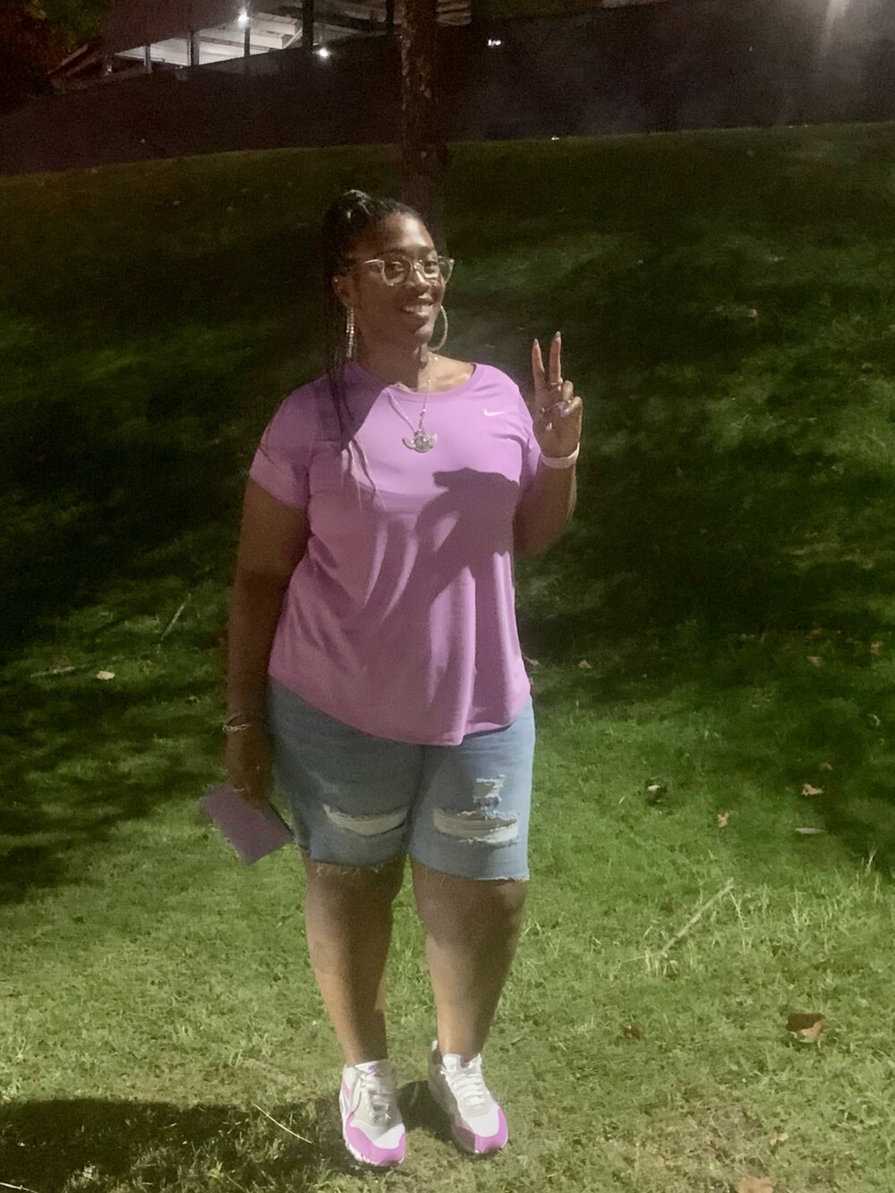 パープル系のTシャツ/カットソー、パープル系のクラッチバッグ、パープル系のスニーカーを着用したレディースの秋コーディネートの2枚目の写真