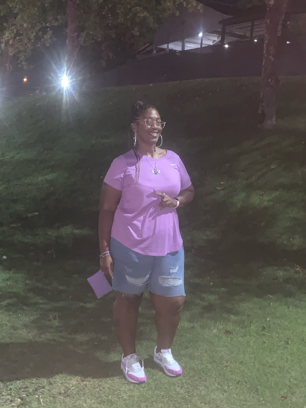 パープル系のTシャツ/カットソー、パープル系のクラッチバッグ、パープル系のスニーカーを着用したレディースの秋コーディネートの4枚目の写真