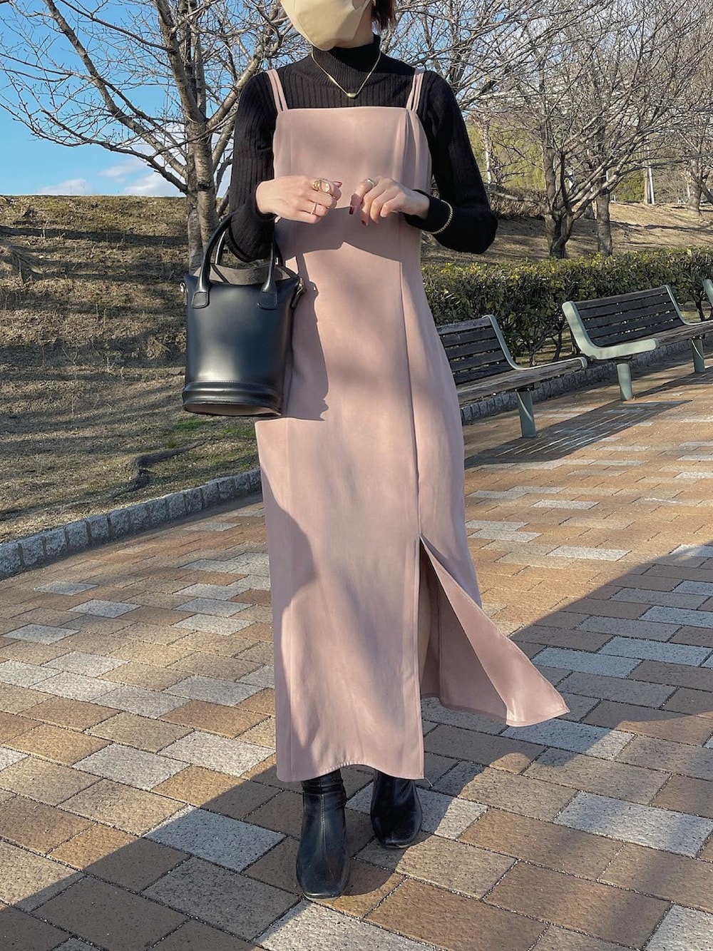 ピンク系のワンピース、ブラック系のバッグ、ブラック系のブーツを着用したレディースの冬コーディネートの2枚目の写真