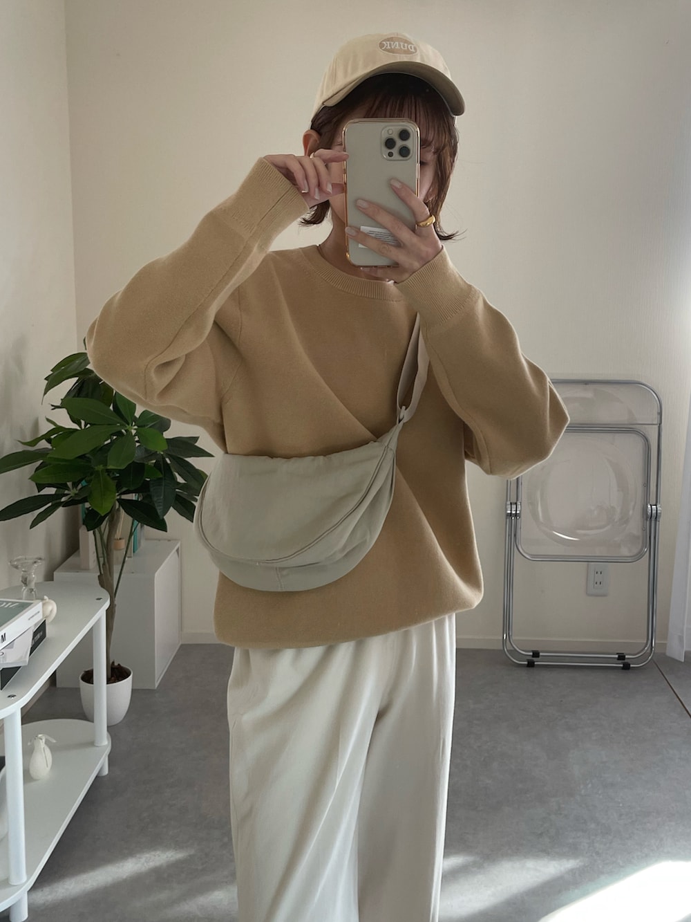 ホワイト系のショルダーバッグ、ベージュ系のニット/セーター、ベージュ系のキャップを着用したレディースの冬コーディネートの3枚目の写真