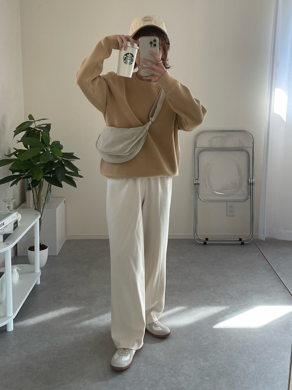 ホワイト系のショルダーバッグ、ベージュ系のニット/セーター、ベージュ系のキャップを着用したレディースの冬コーディネートの2枚目の写真