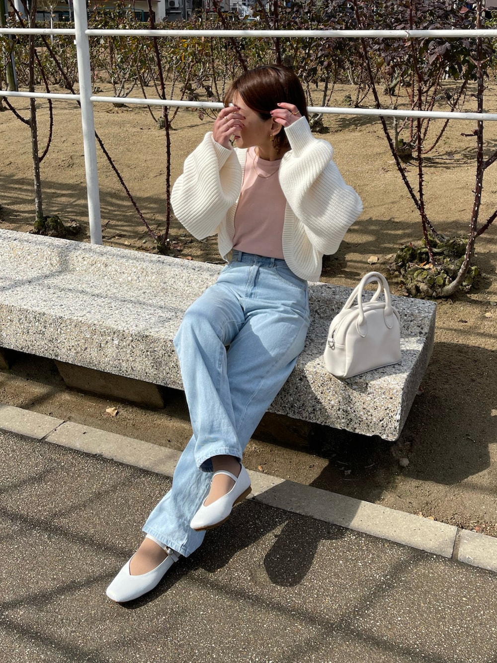 ピンク系のTシャツ/カットソー、ホワイト系のカーディガン/ボレロ、ブルー系のデニムパンツを着用したレディースの春コーディネートの3枚目の写真