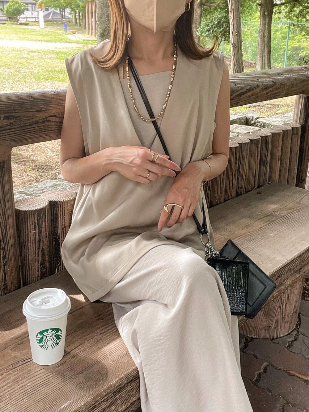 ベージュ系のベスト、ブラック系のショルダーバッグ、ベージュ系のワンピース/ドレスを着用したレディースの夏コーディネートの4枚目の写真