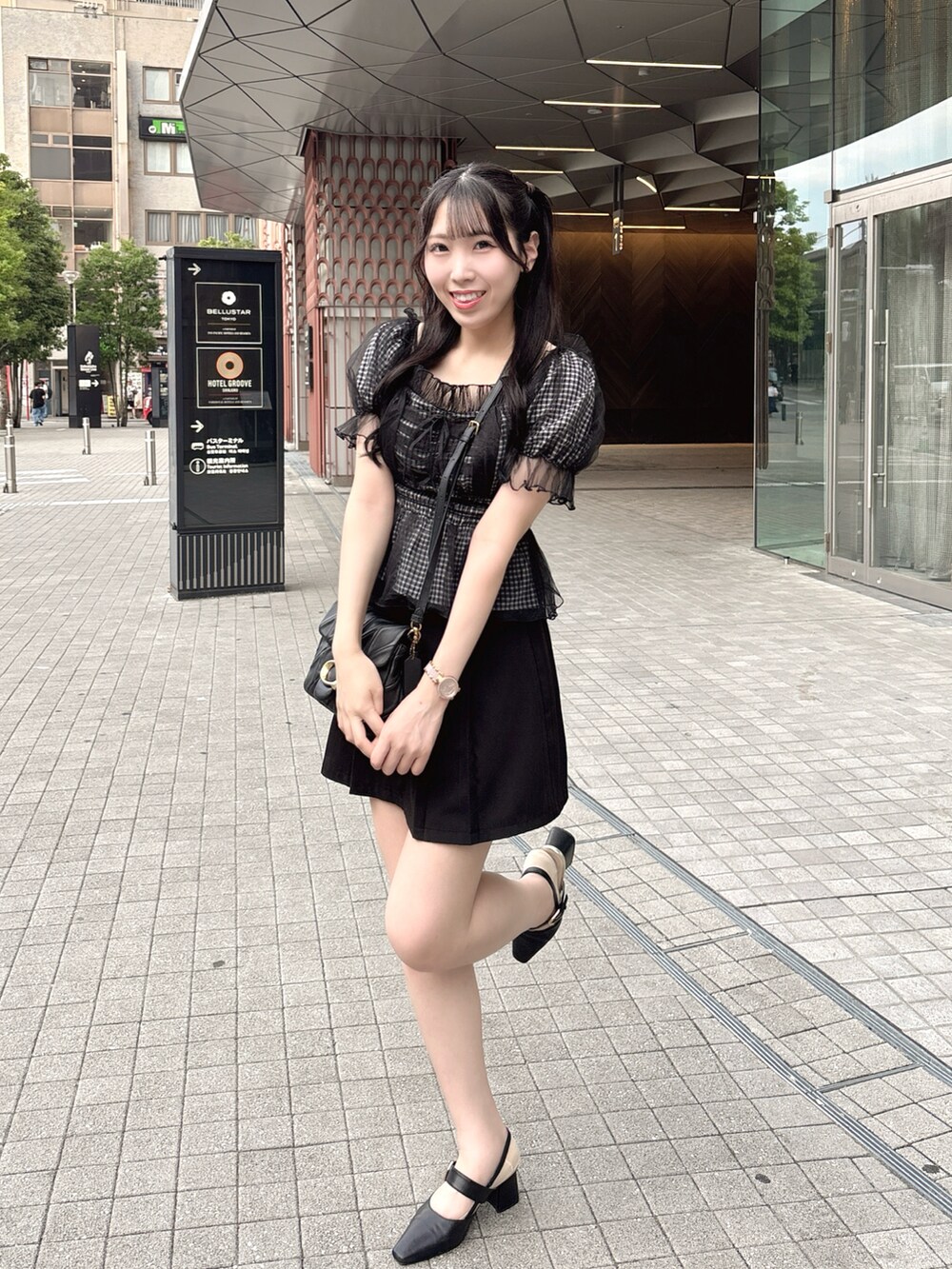 ブラック系のショルダーバッグ、ブラック系のパンプス、ブラック系のシャツ/ブラウスを着用したレディースの夏コーディネートの3枚目の写真