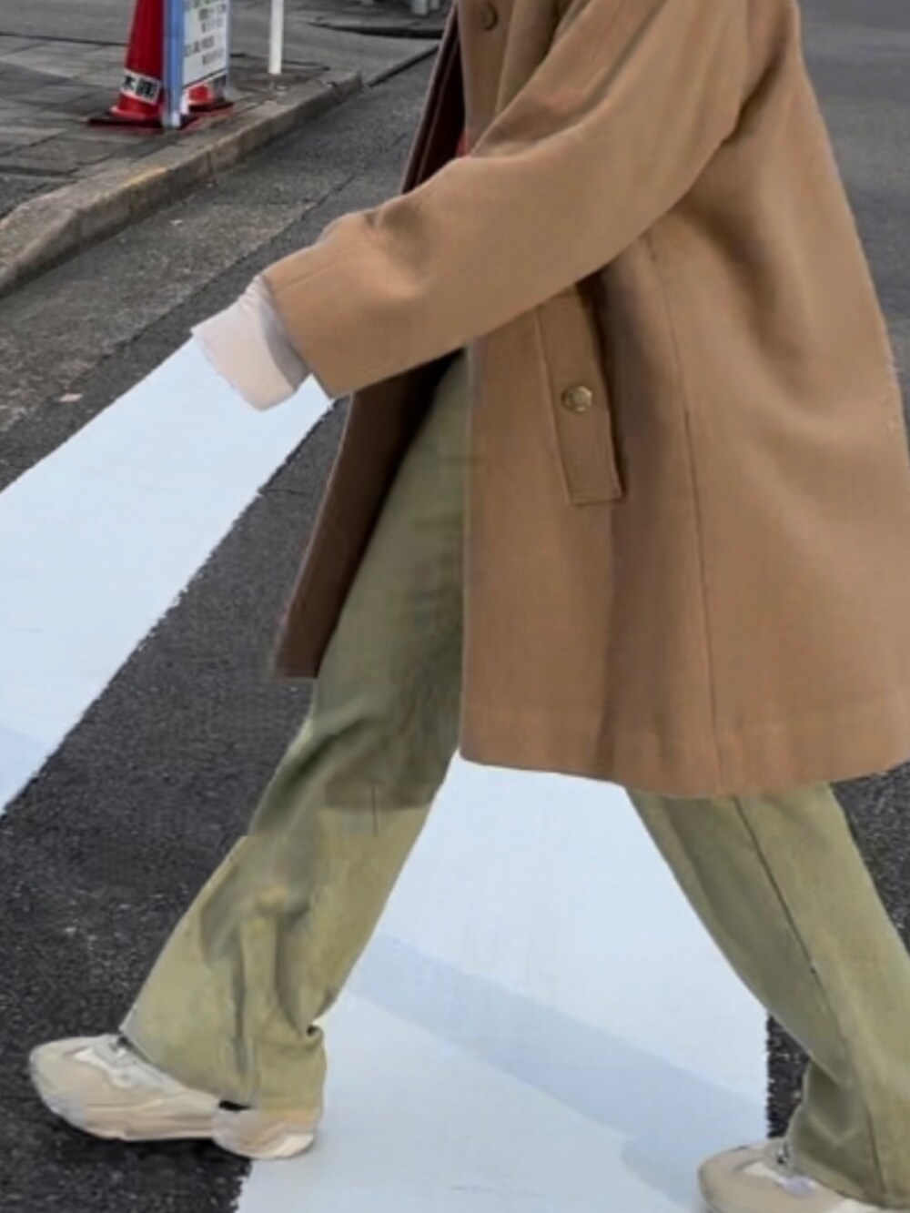 レッド系のニット/セーター、グリーン系のスラックス、ホワイト系のTシャツ/カットソーを着用したレディースの冬コーディネートの2枚目の写真